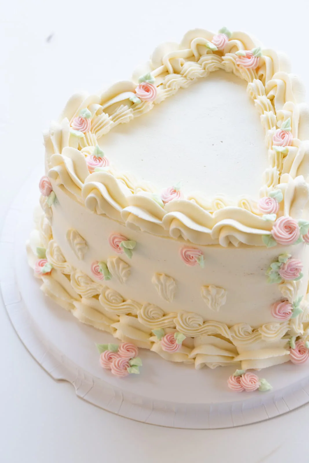 Ivory vintage-piped cake with pastel rosettes