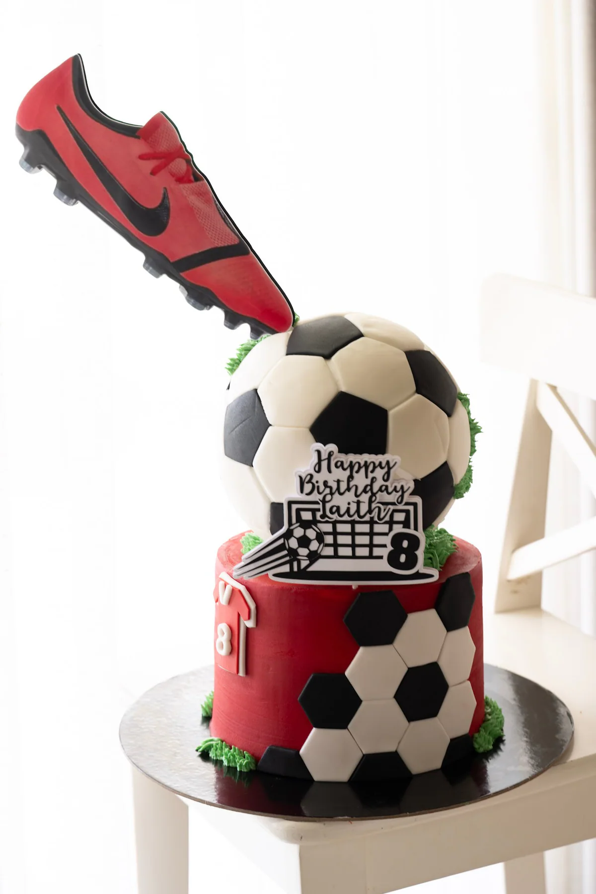 Football birthday cake with a suspended red boot