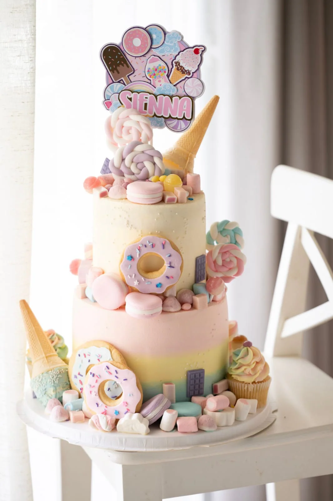 Pastel tiered children's cake with ice cream and donuts