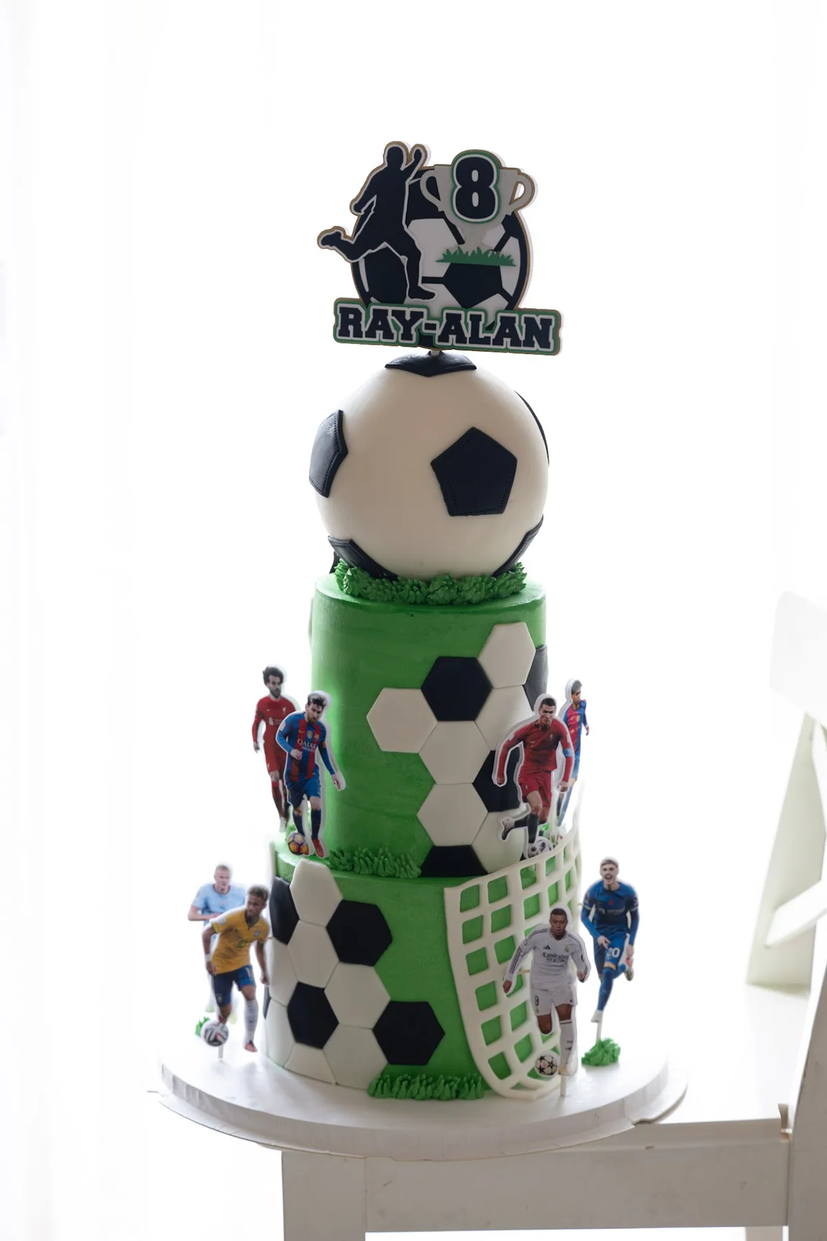 Two-tier football and superhero birthday cake