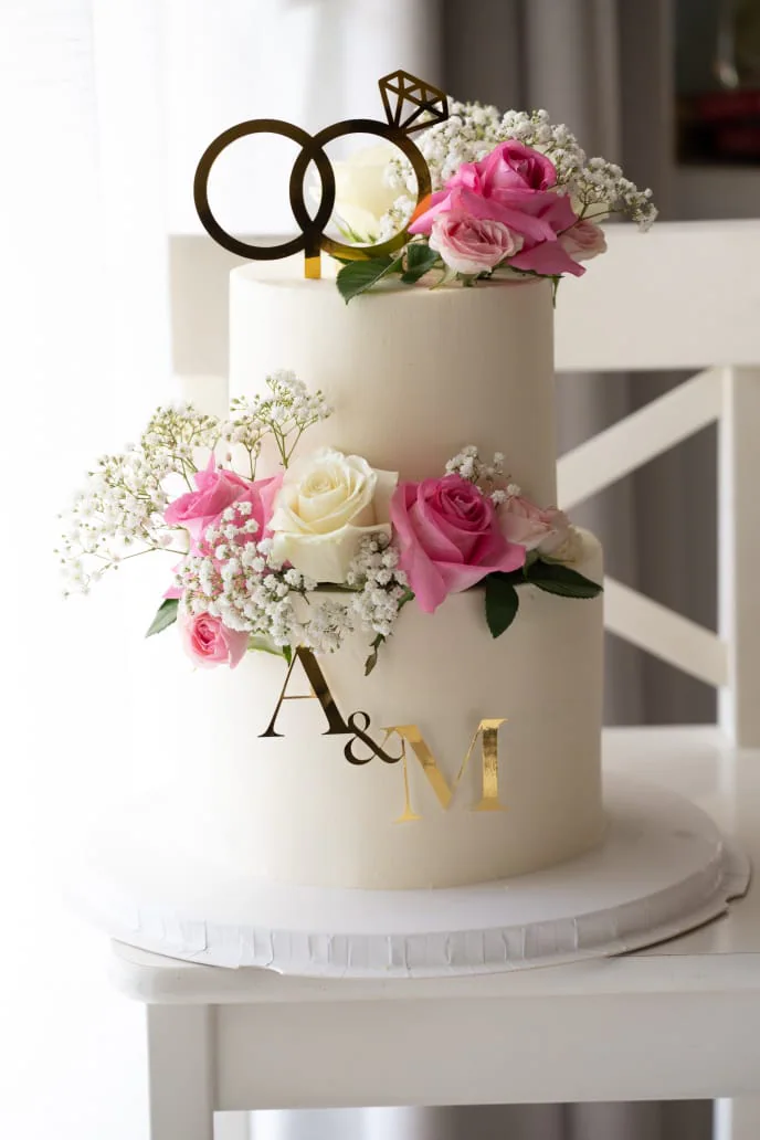 Two-tier engagement cake with rings and pink roses