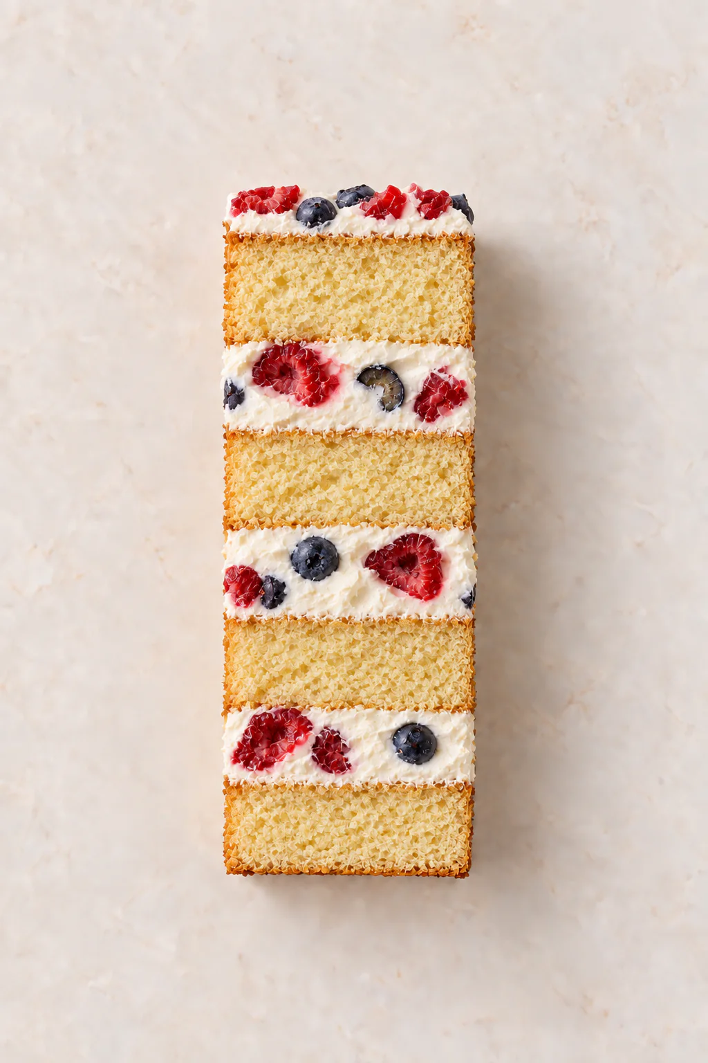 A cut slice of Vanilla Cake with Mascarpone & Whipped Cream Filling