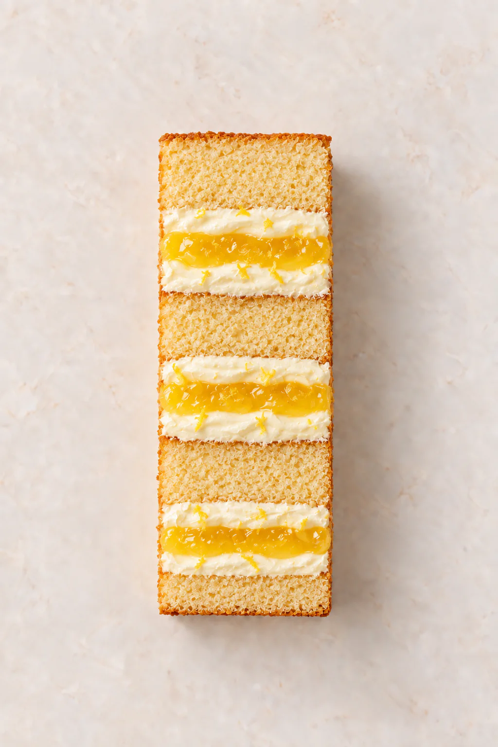 A cut slice of Vanilla Cake with Lemon Curd Filling