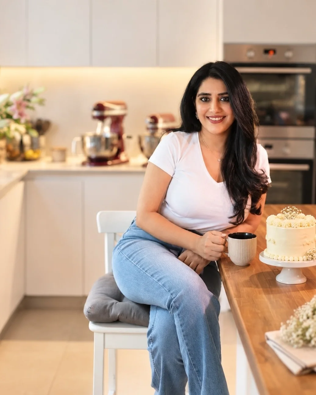 Upasana, founder of A Cake Affair, in her kitchen beside a cake